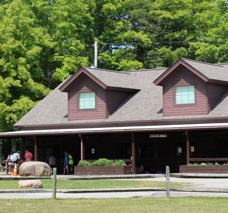 Taylor Hall, a large, brown cabin-like camp building.